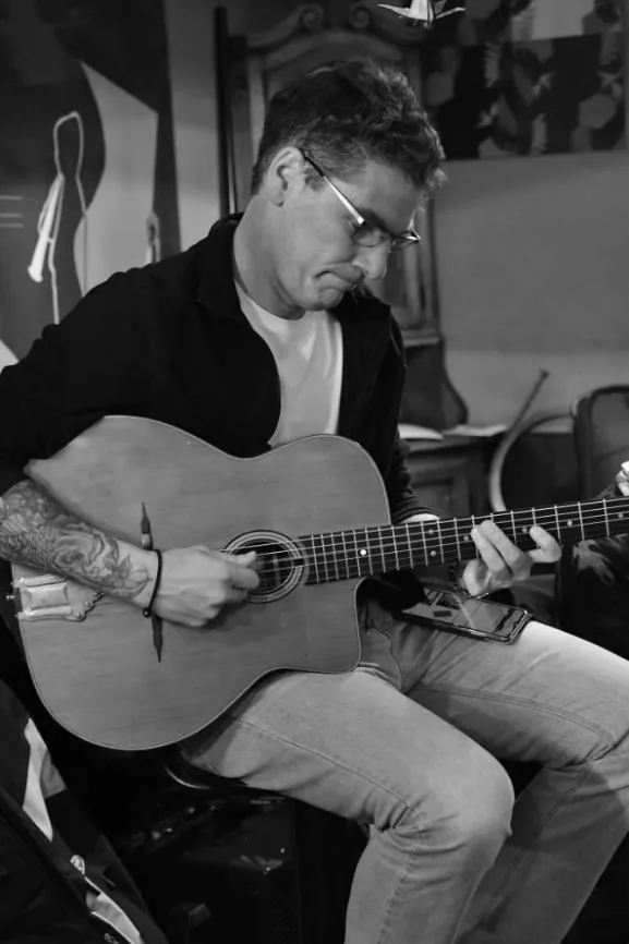 Un guitariste de Balance ton Swing joue de la guitare manouche, en noir et blanc